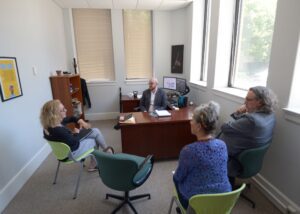 A group of people sitting around a desk.