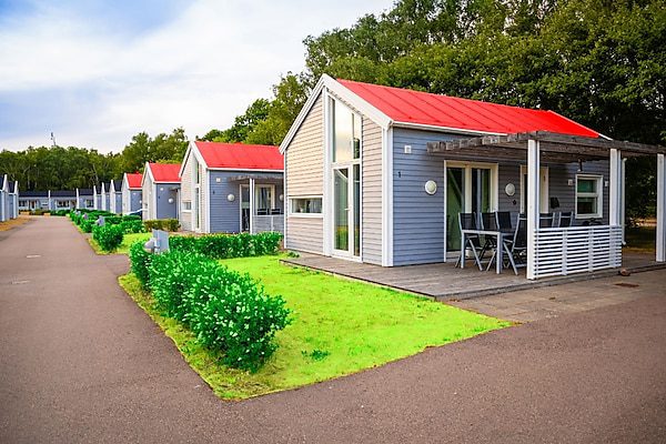 A row of houses with red roofs and green grass.