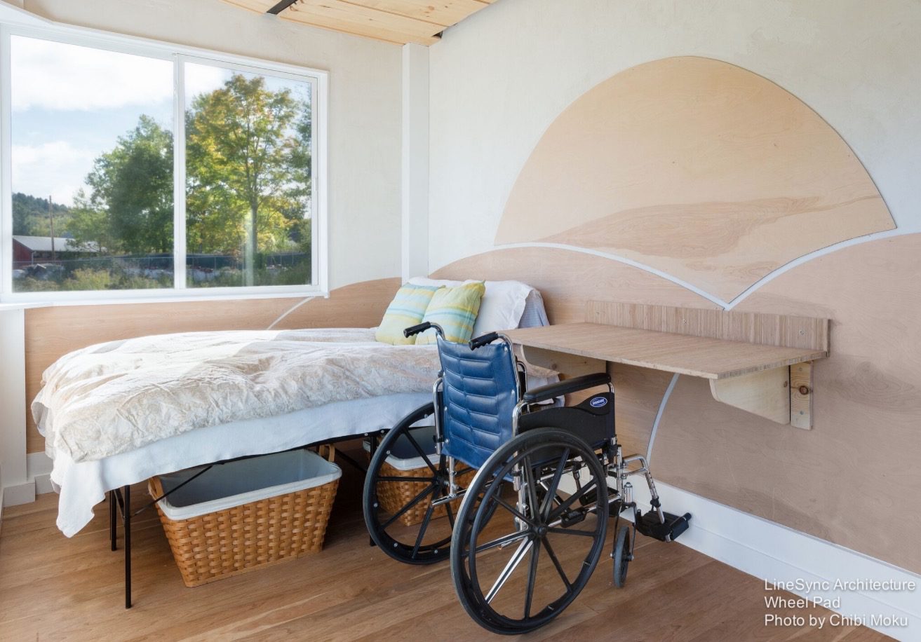 A wheelchair sitting in front of a bed.